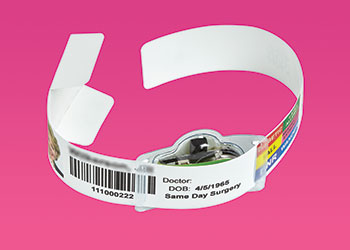 A hospital patient bracelet with additional electronics attached to it.