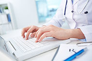 doctor typing on laptop