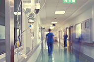 Hospital corridor with IV and blurry nurses