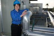 Woman engineer standing next to rooftop chiller