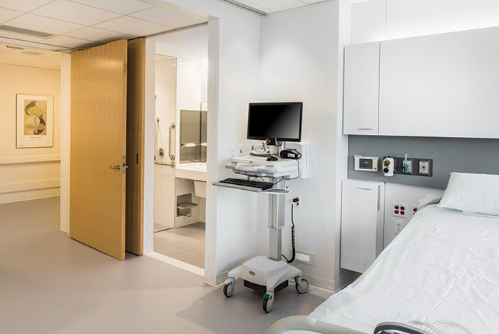 patient room with computer on rolling cart