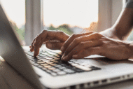 Man's hands typing on laptop