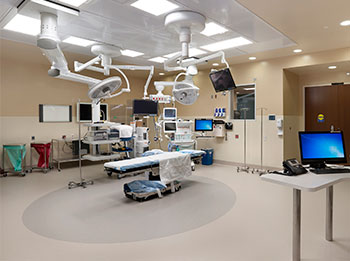 A hospital operating room with high-tech equipment around an operating bed