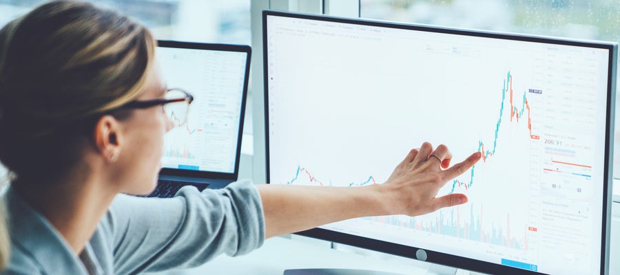 A woman looks at a graph on a computer screen