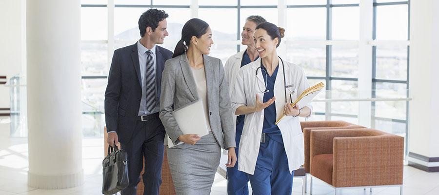 hosptial staff walking and talking with buisiness people