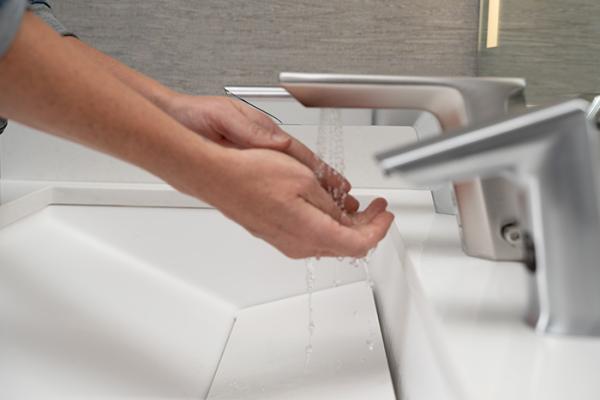 Woman washing hands at automatic handwash sink