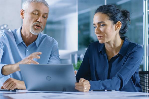 Facility workers looking at laptop screen