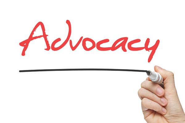 Person writing "Advocacy" on white board