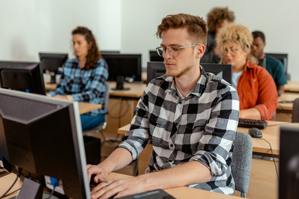 Professional in classroom setting taking exam on computers