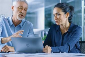 Facility workers looking at laptop screen