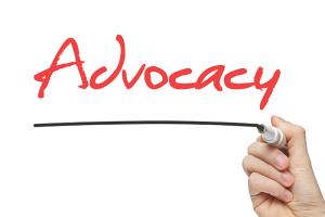 Person writing "Advocacy" on white board