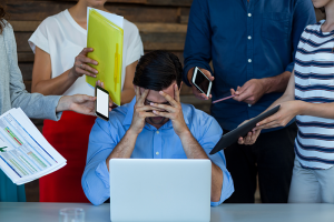 Man visibly frustrated by colleagues demanding his attention 