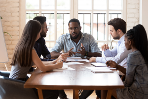 Small team meeting, sitting around rectangular table